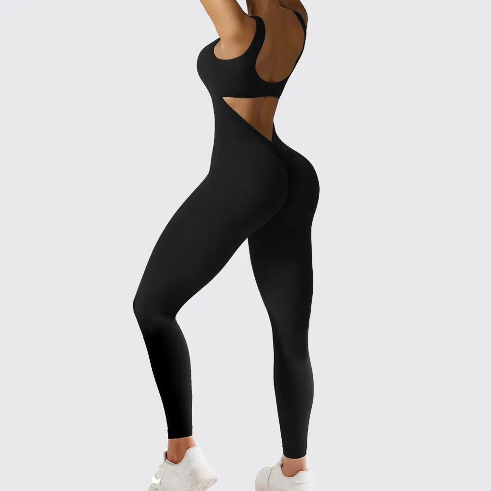 Woman wearing a sleeveless army green flare jumpsuit for yoga.