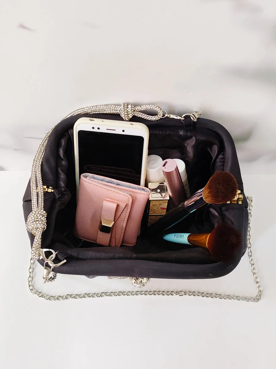 Women's soft polyester shoulder messenger bag in shell shape with diamond folds and chain detail.