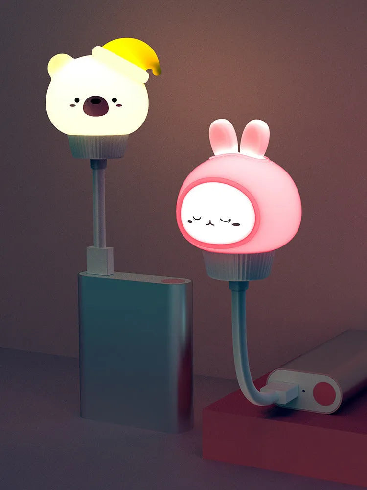 USB portable cartoon animal LED night light with remote control on a bedside table