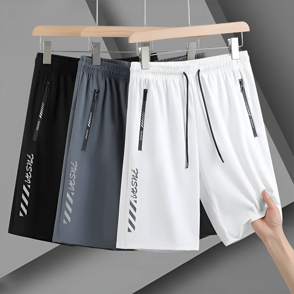 Men's black quick-drying nylon sports shorts with a loose fit and mid-thigh length on a grey background.
