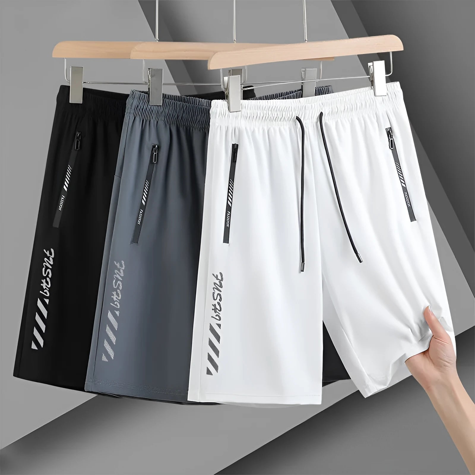Men's black quick-drying nylon sports shorts with a loose fit and mid-thigh length on a grey background.