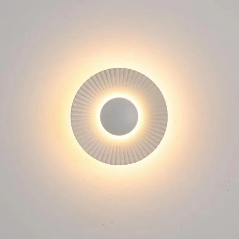 Round wall lamp with aluminium shade in a two-tone white and gold colour combination, mounted on a plain wall.