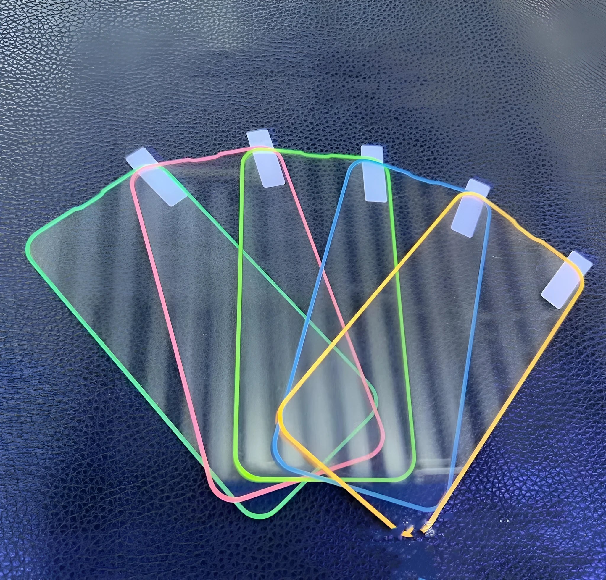 Fluorescent glowing tempered glass screen protector for iPhone on a dark background.