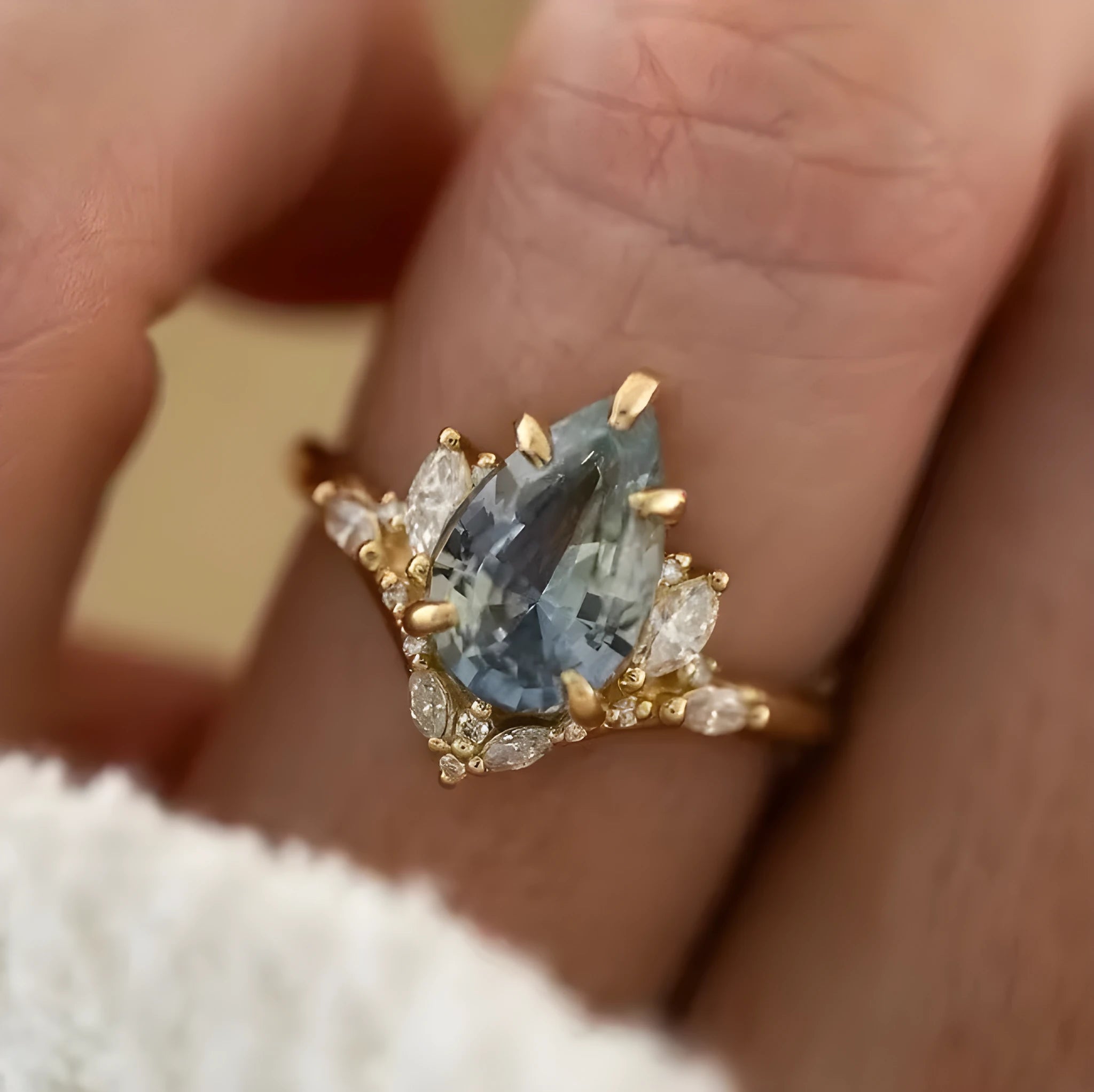 Gold alloy ring with blue crystal diamond inlay and floral design on white background