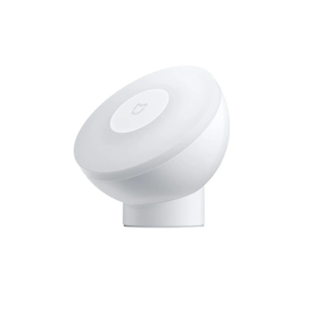 White cube-shaped Mijia bedside night light with motion sensor and Bluetooth on a wooden table.