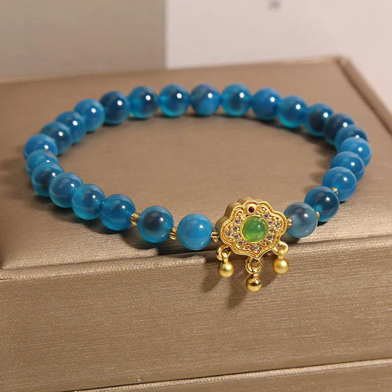 Blue agate safety lock pendant on a crystal women's bracelet with rhinestone details.