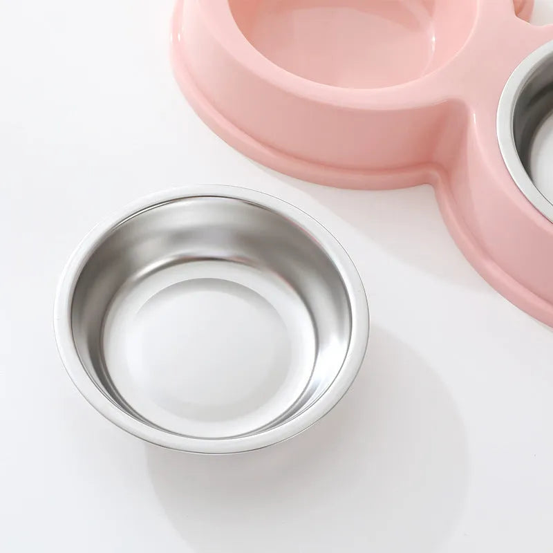 Blue stainless steel frog-shaped double pet bowl for food and water on a floor.