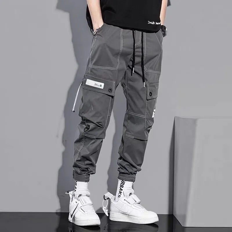 Men's loose fit solid colour polyester trousers in gray, front view, for casual autumn wear
