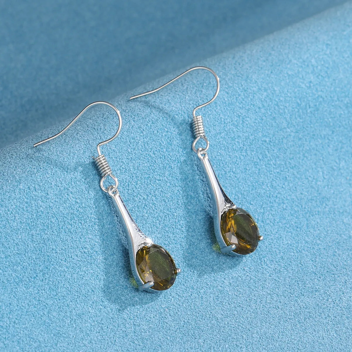 A pair of olive green retro-style drop earrings made from alloy on a white background.
