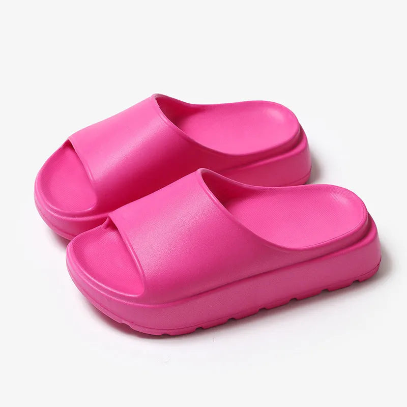 Women's beige fish mouth slippers with a thick sole on a wooden floor.