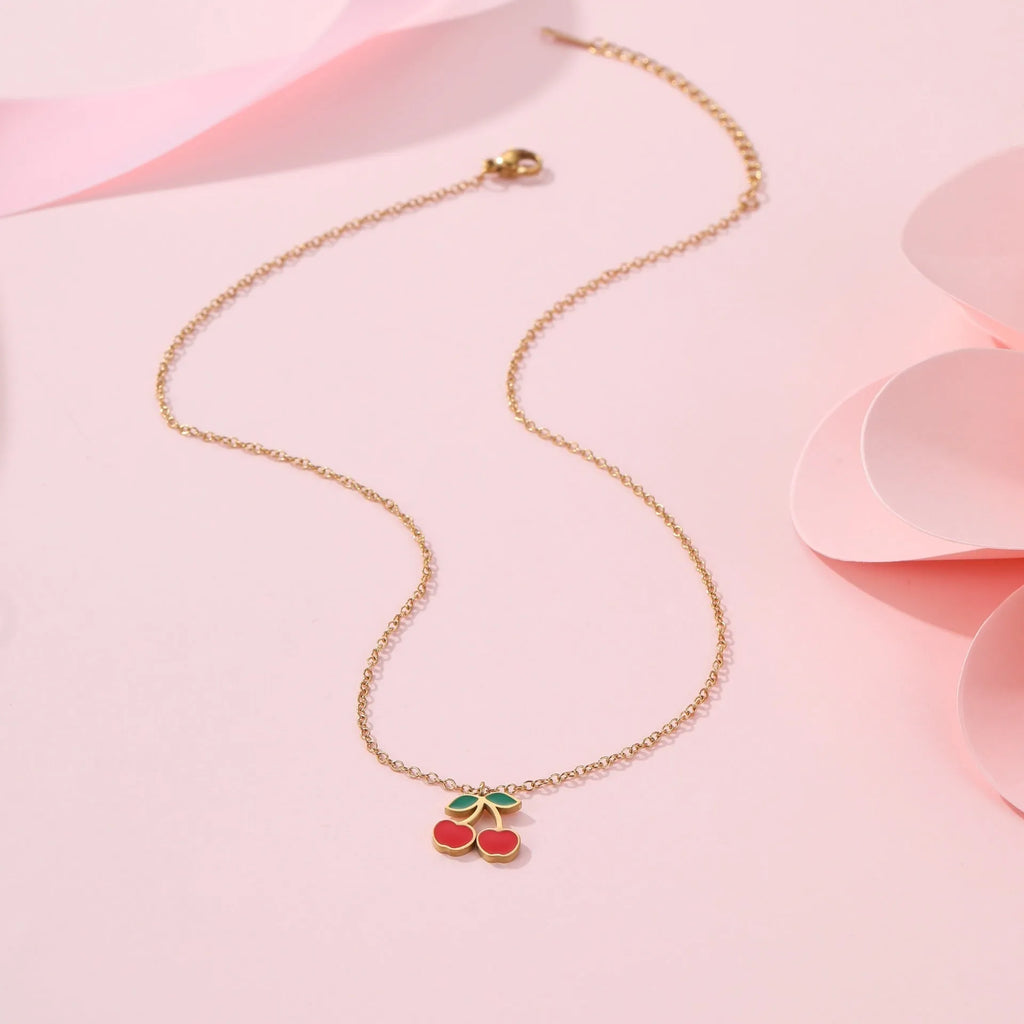 Complete cherry jewellery set showing stainless steel necklace, bracelet, earrings, and ring pieces with electroplated colour finishes