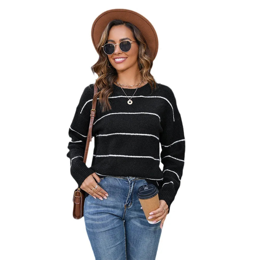 Women's black and white striped loose fit pullover sweater with round neck and long sleeves.