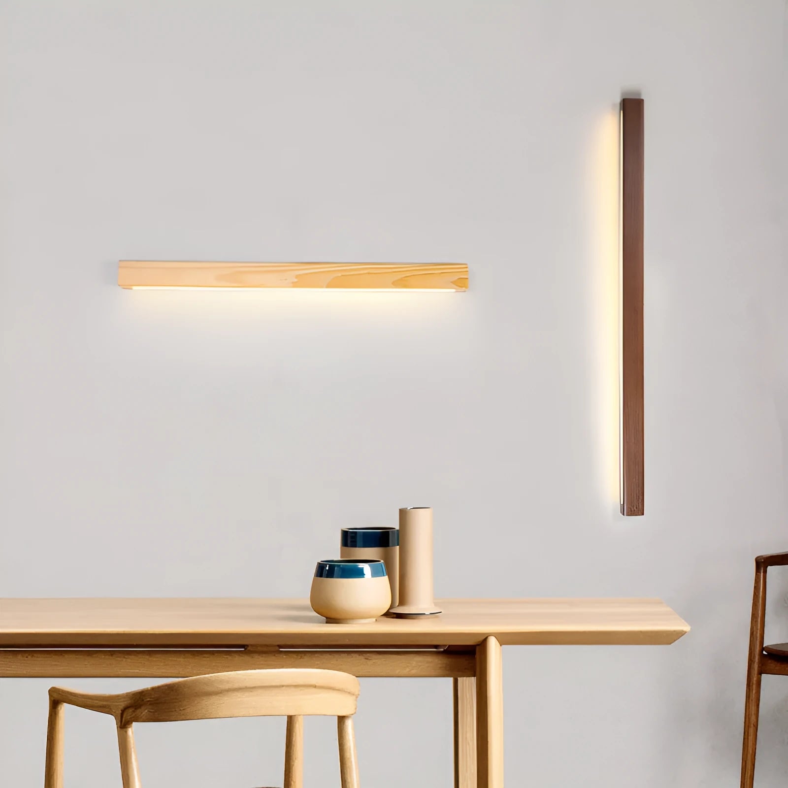 Walnut colour wood and acrylic strip wall lamp in three lengths on a white wall.
