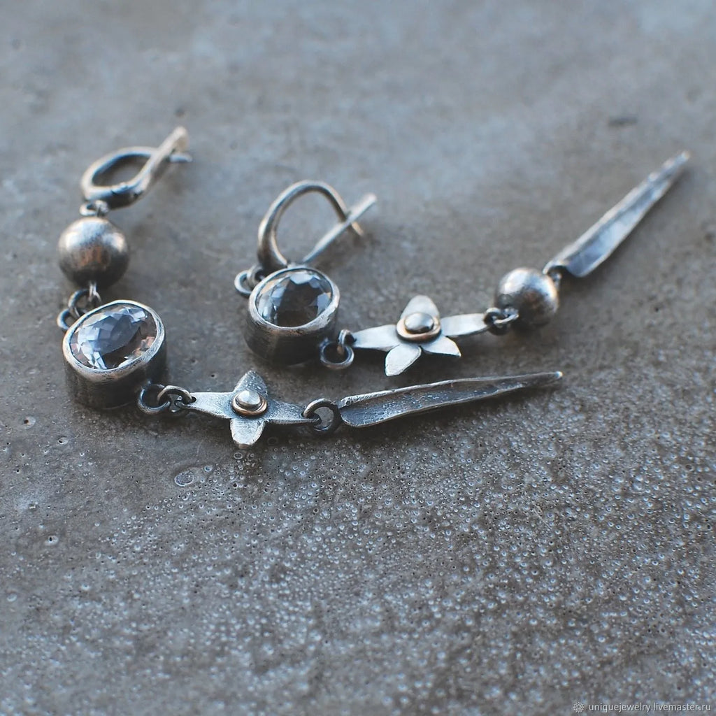 Geometric long pendant earrings with rhinestone drops in antique silver finish.
