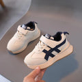 Children's white synthetic leather sneaker with Velcro strap on a rubber sole.
