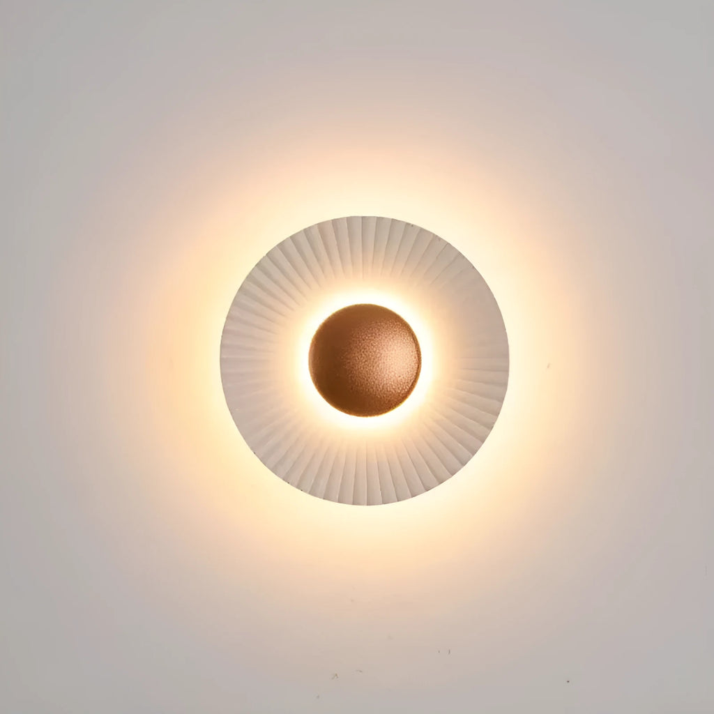 Round wall lamp with aluminium shade in a two-tone white and gold colour combination, mounted on a plain wall.