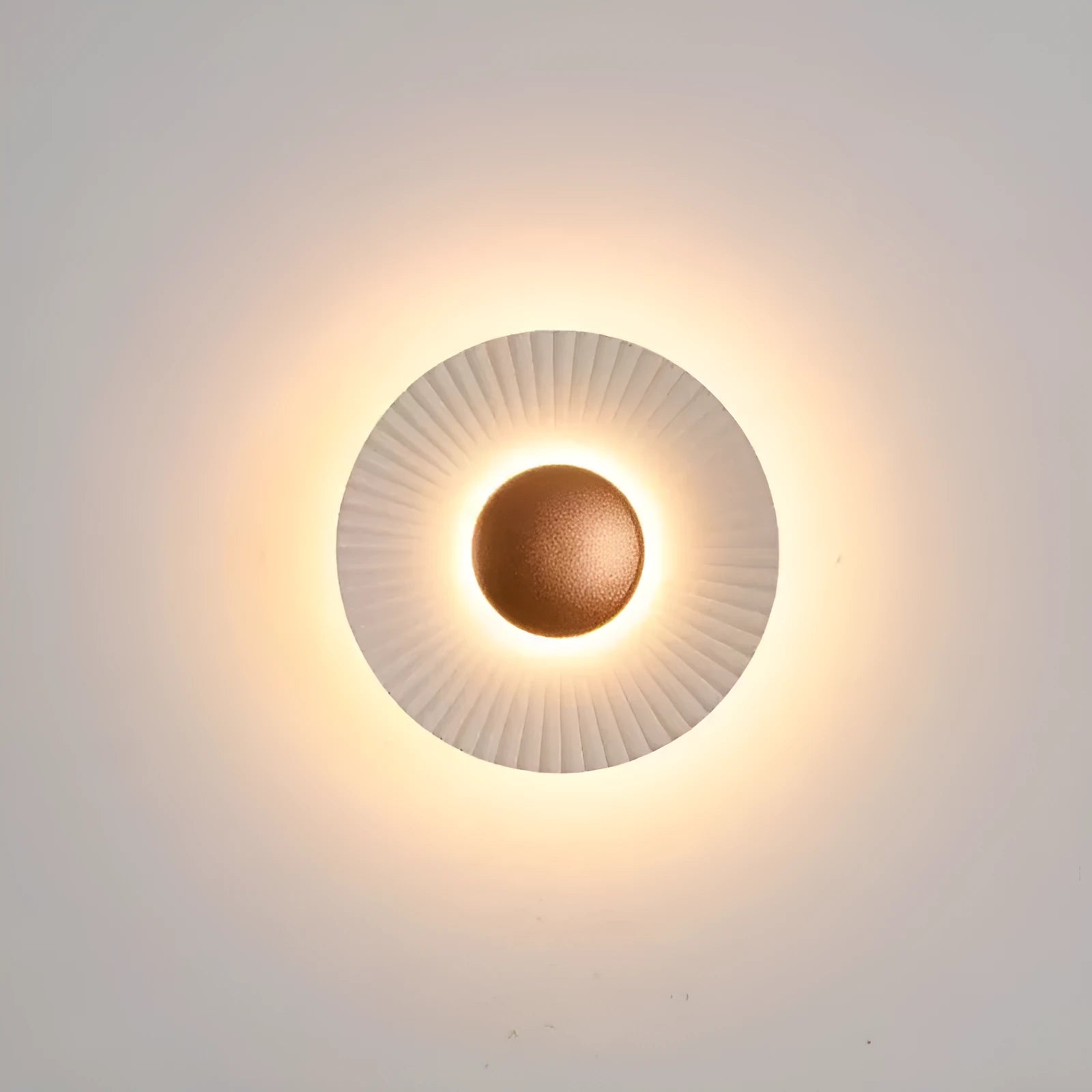 Round wall lamp with aluminium shade in a two-tone white and gold colour combination, mounted on a plain wall.