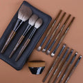 12-piece makeup brush set with wooden handles and a grey PU storage pouch.