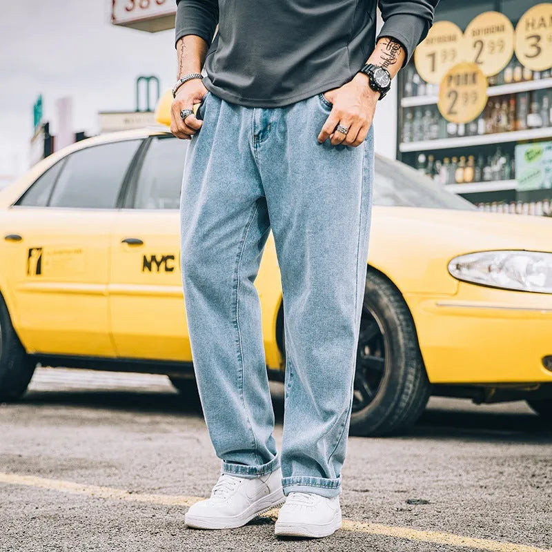 Men's loose straight-cut cotton jeans in dark blue, shown on a man in a casual setting.