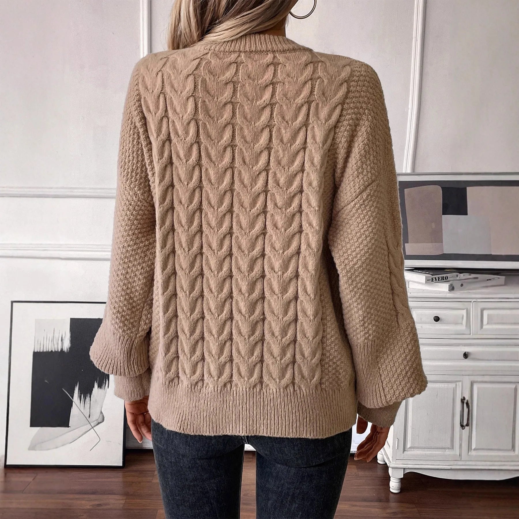 Beige women's loose round neck sweater with a twist design detail on the front.