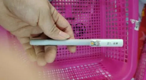 Black gel pen with full needle tube design on white surface, plastic body, cap on