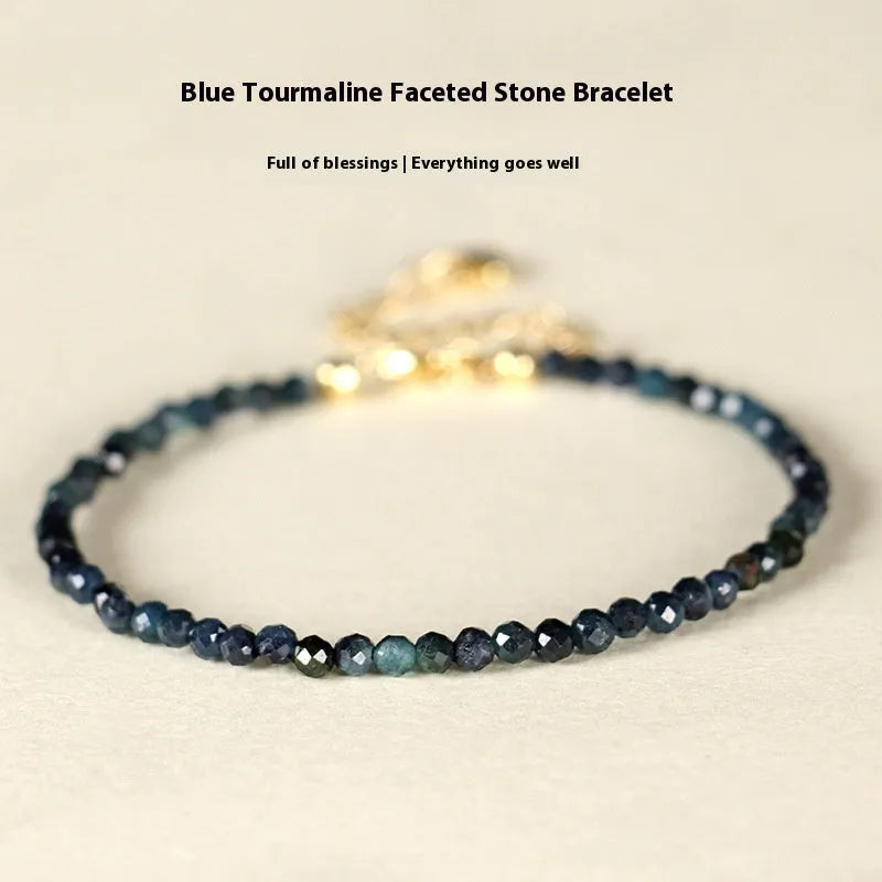 Close-up of a 3mm blue tourmaline cut bead spacer bracelet on a wrist.