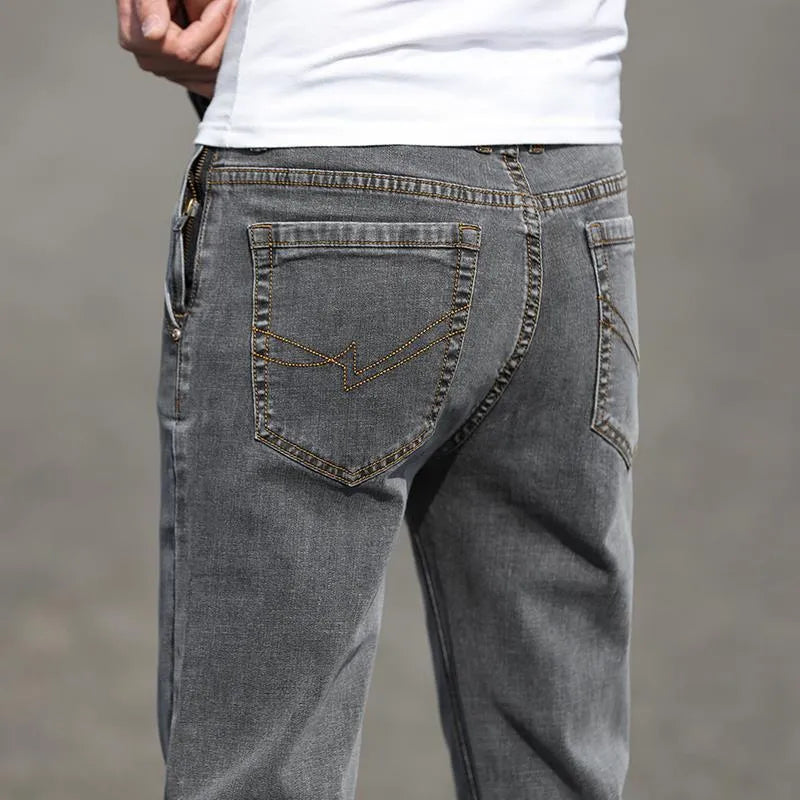 Man wearing smoky grey straight leg jeans with low waist and zipper fly.