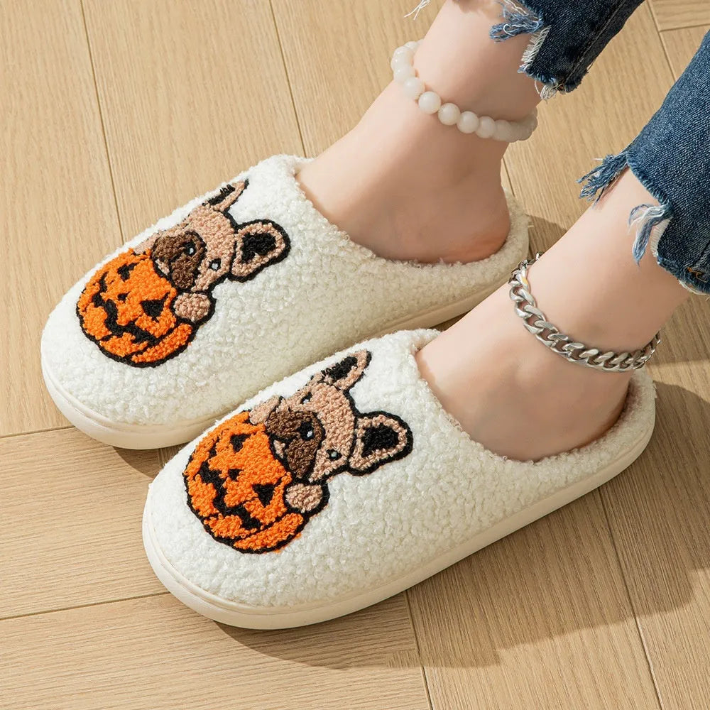 Black and white Halloween slippers with pumpkin design featuring plush uppers and non-slip rubber soles.
