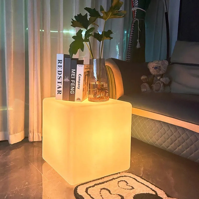 Square LED cube stool light in garden setting showing modern design with lighting