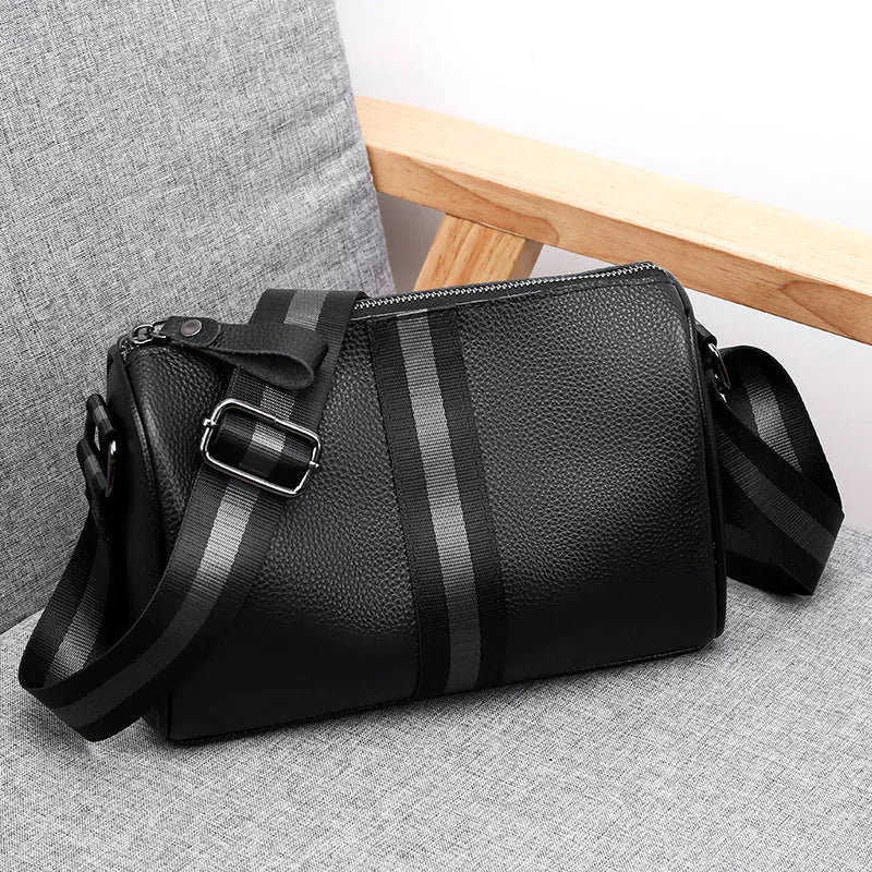 Black genuine leather crossbody bag showing single shoulder strap and structured 24x16x13cm design.