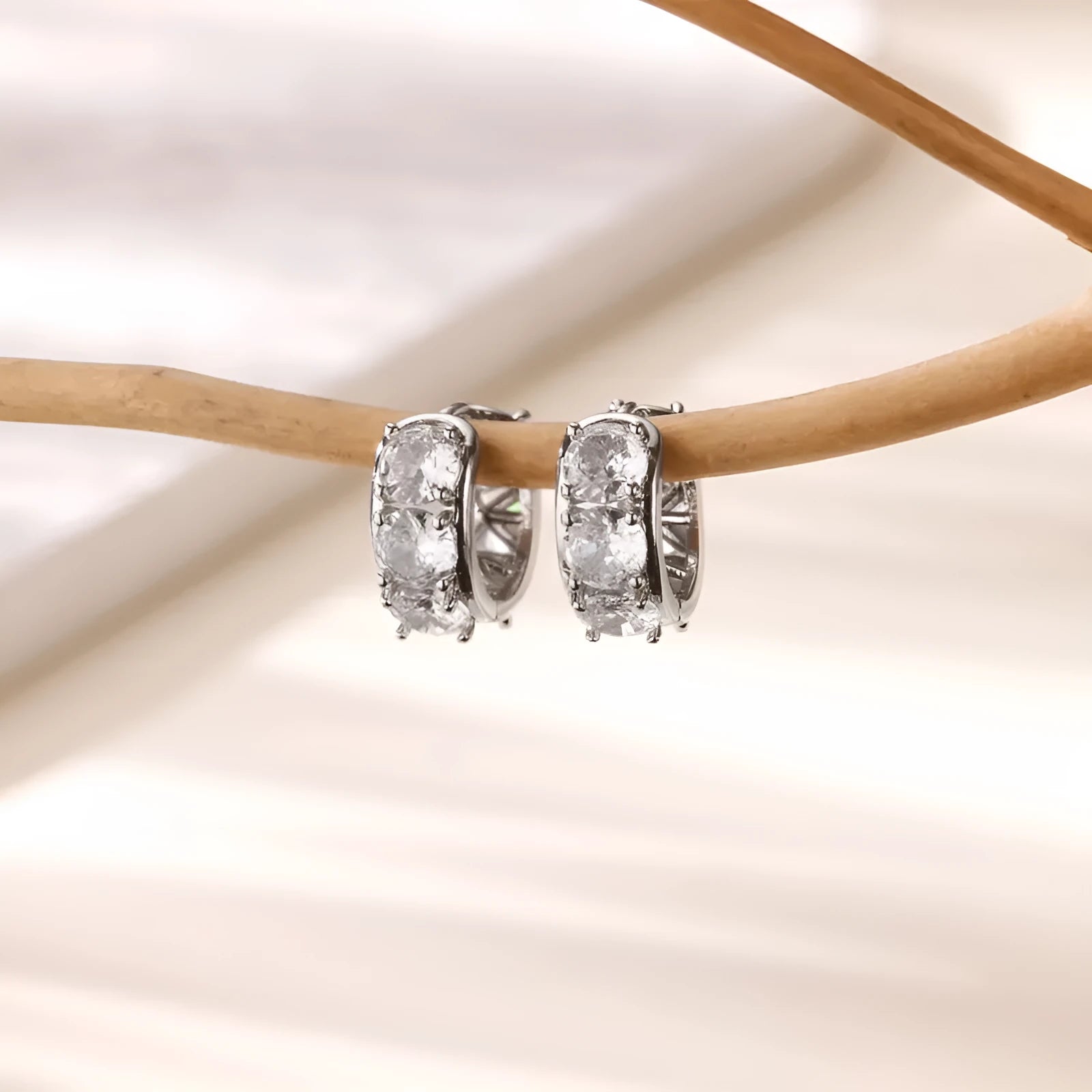 Women's silver-tone U-shaped clip earrings with small sparkling zircon stone details on a white background.