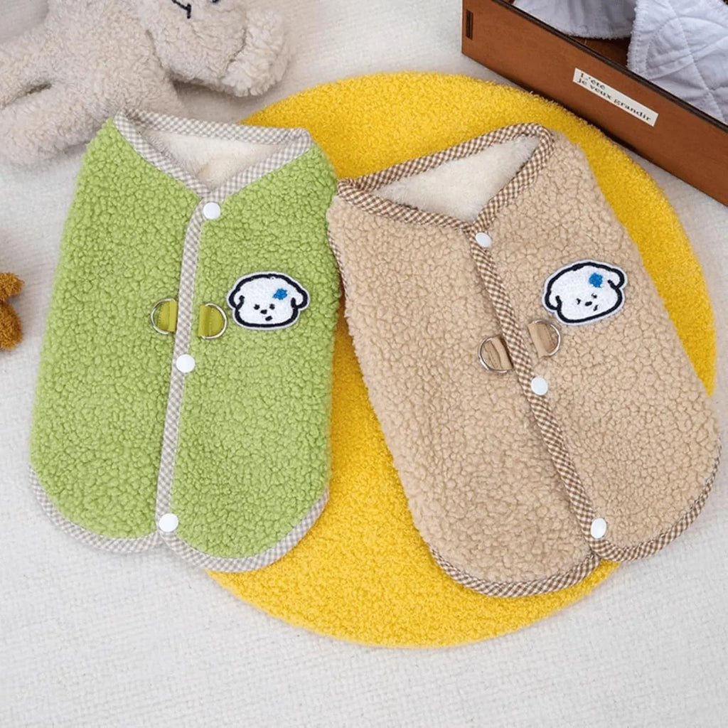 Green coral fleece dog vest with a metal leash ring on the back, fastened at the side on a small dog.