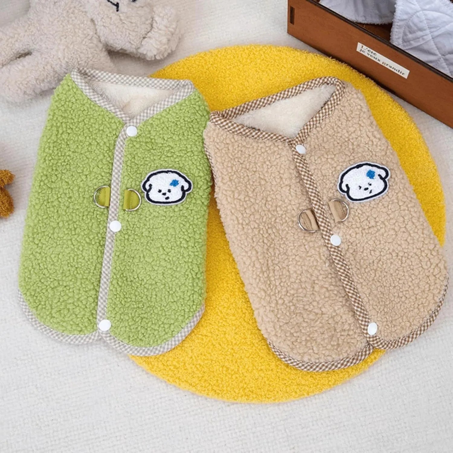 Green coral fleece dog vest with a metal leash ring on the back, fastened at the side on a small dog.