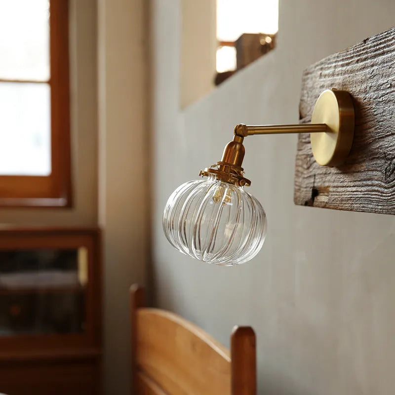 Pumpkin shaped transparent glass wall lamp with water ripple texture mounted on a wall