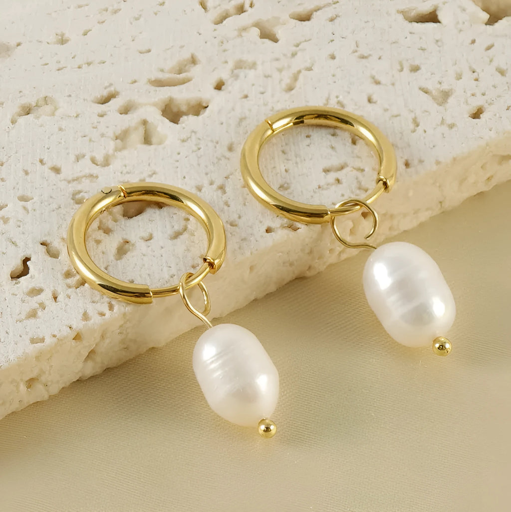 A pair of gold-coloured geometric stud earrings with a single pearl accent on each.