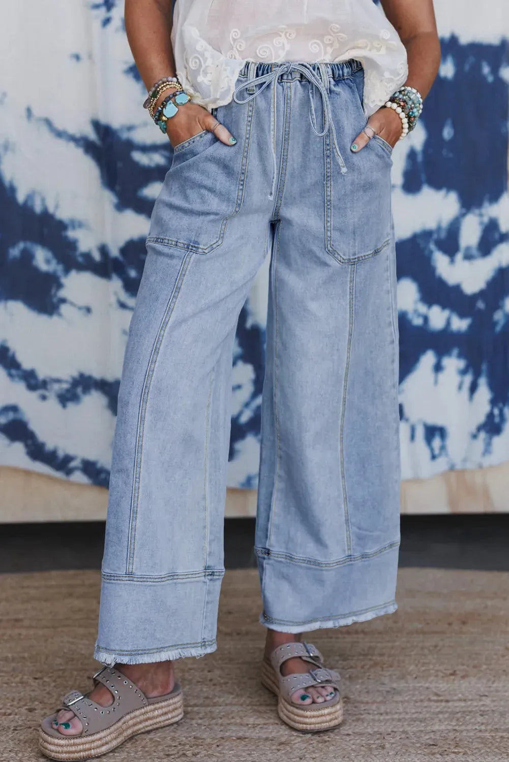 Beau blue wide leg denim pants with elastic drawstring waist and raw hem finish laid flat
