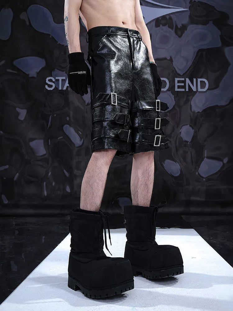 Black men's PU leather cropped shorts on a model, showing medium low waist and casual fit.