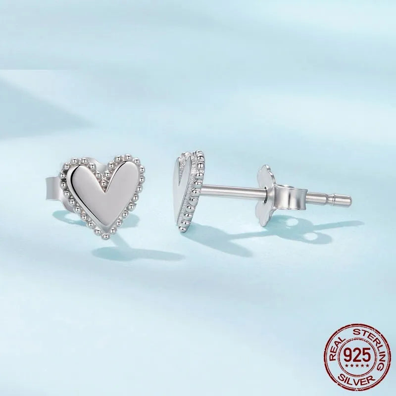 Simple S925 sterling silver heart-shaped ear studs with electroplated finish on a white background