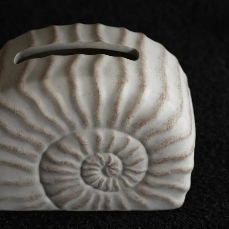 Modern conch shell shaped resin tissue box cover in a conch ramble colour.