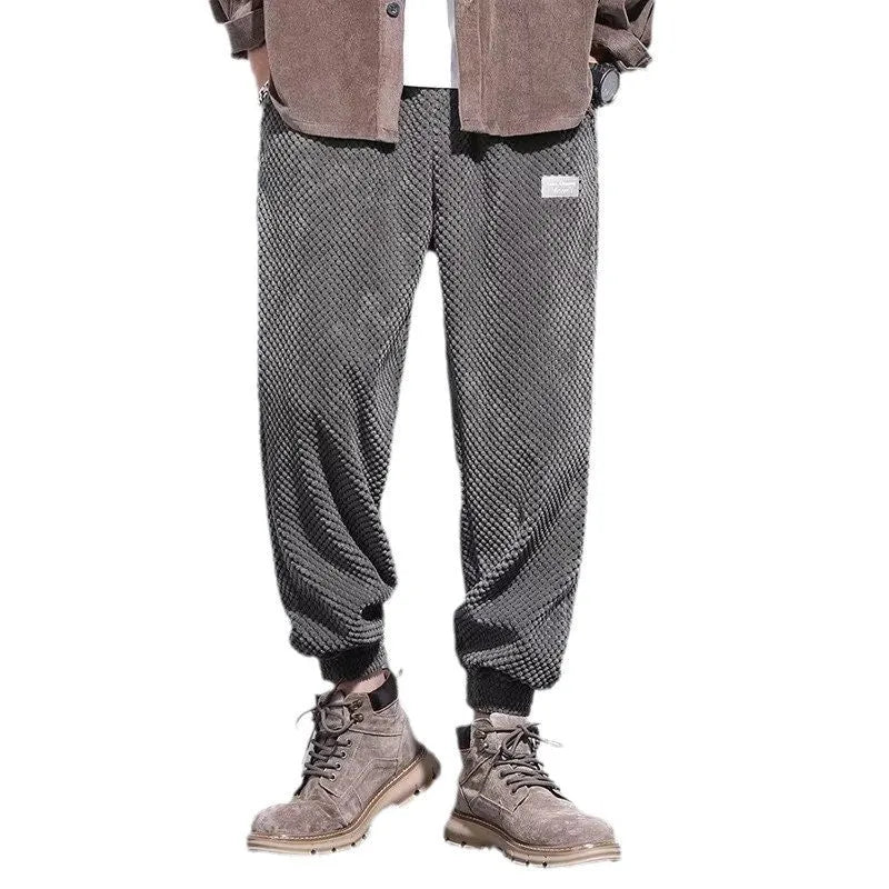 Men's grey ankle-tied straight leg sweatpants laid flat, showing casual sports design.