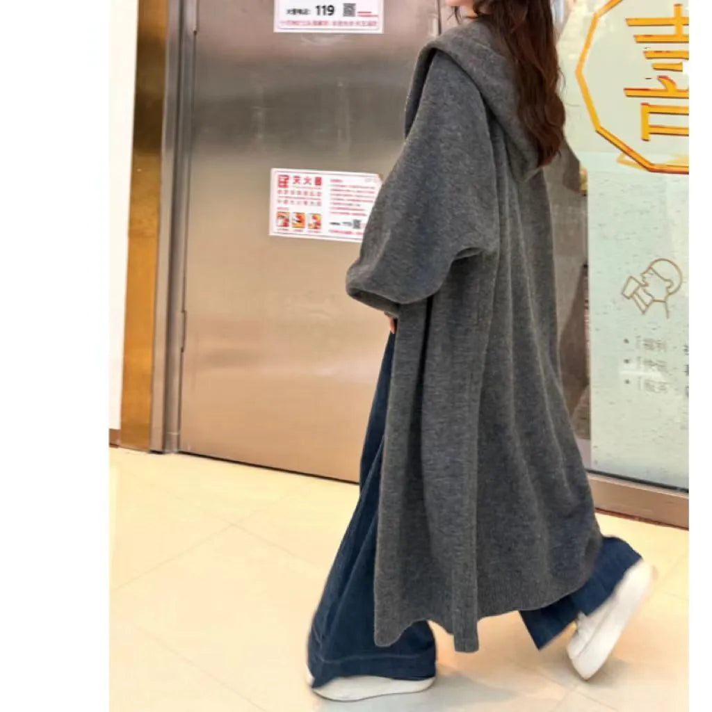 Women's long hooded knitted cardigan in loose fit, shown in oatmeal colour.