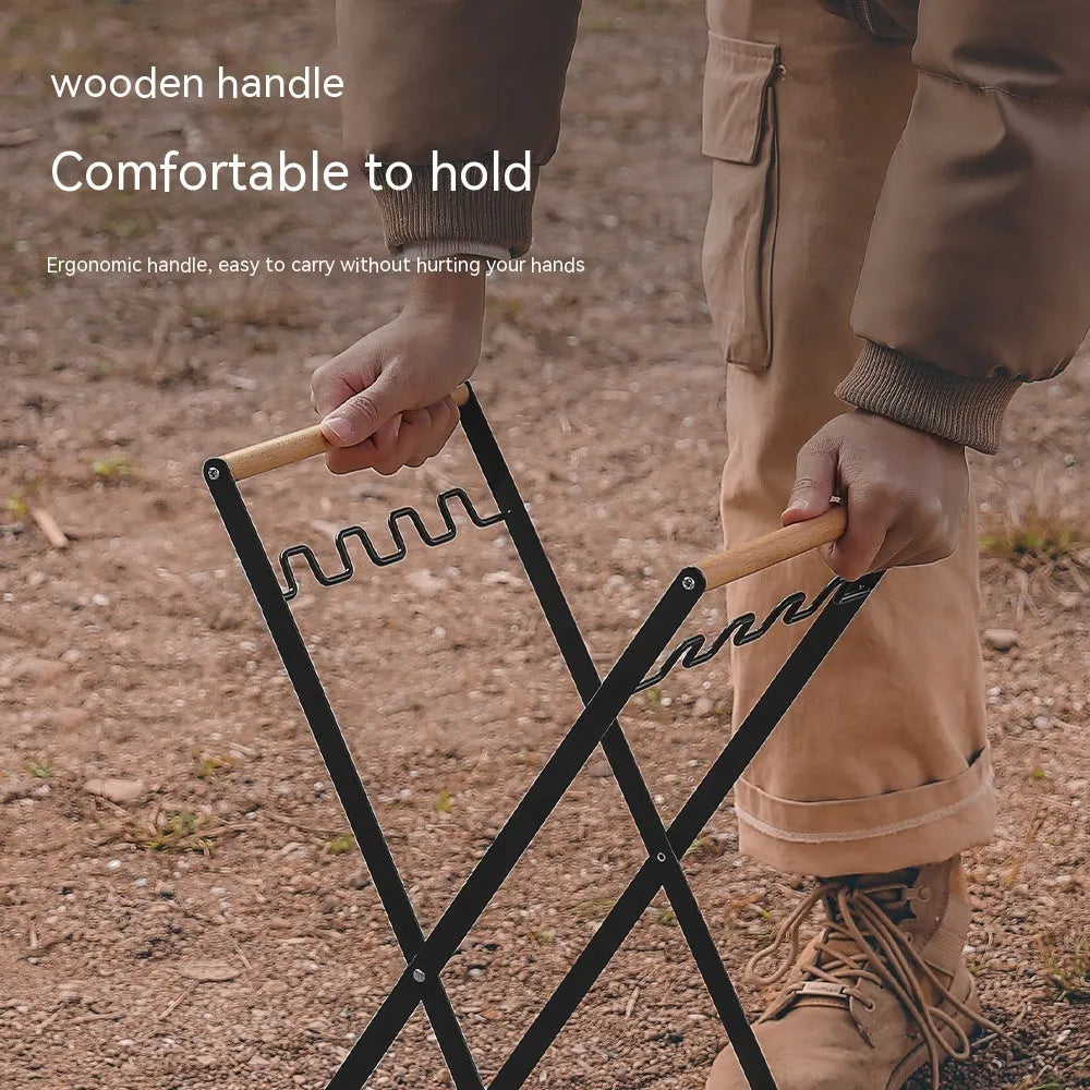 Black outdoor folding trash rack with wooden handle holding a white bin bag open.