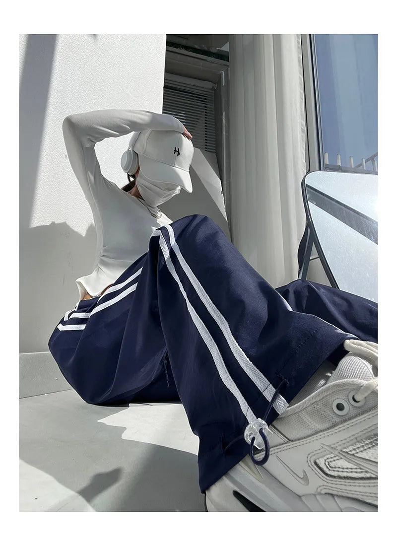 Women's loose straight-leg trousers with contrast ribbon detail in navy blue.