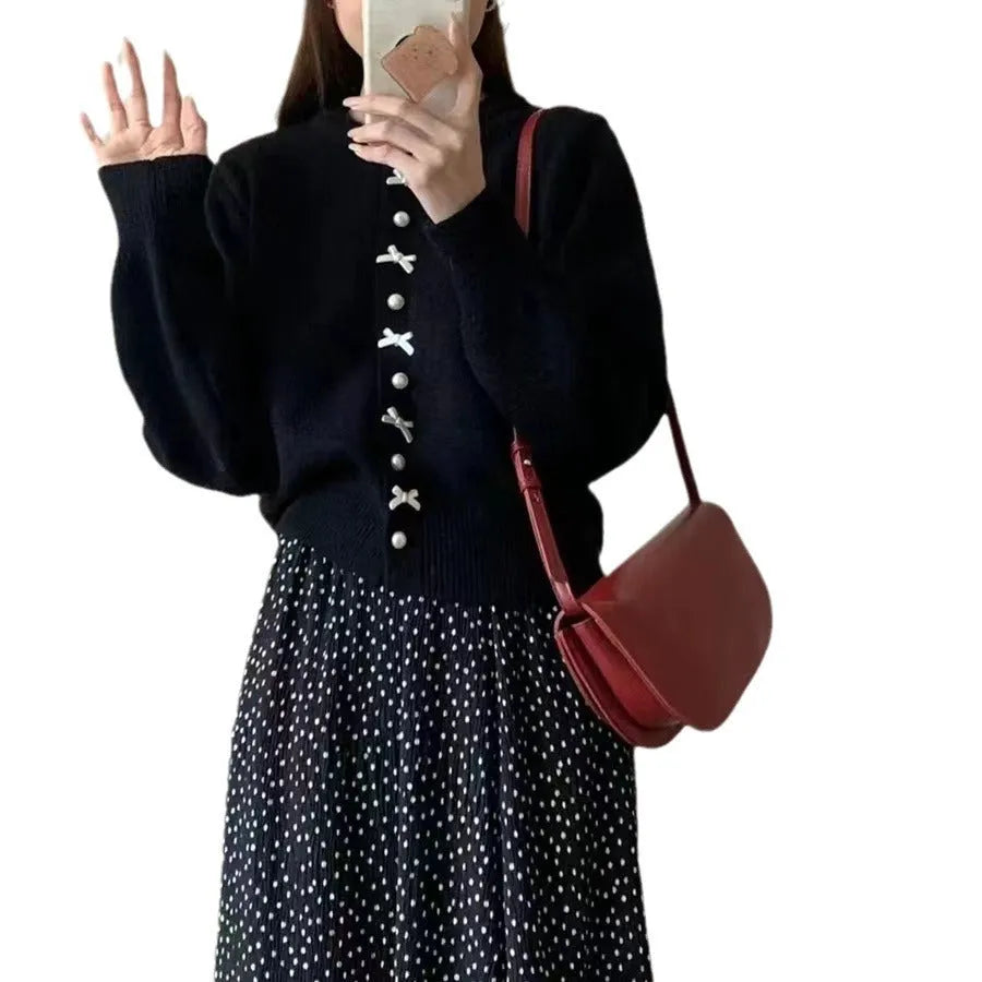 Women's light blue cashmere blend cardigan with white bow and pearl button detail on front.