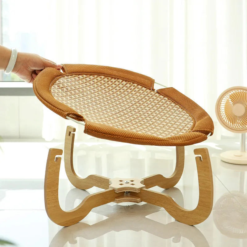 Brown woven rattan square pet bed basket for cats and small dogs on a wooden floor.