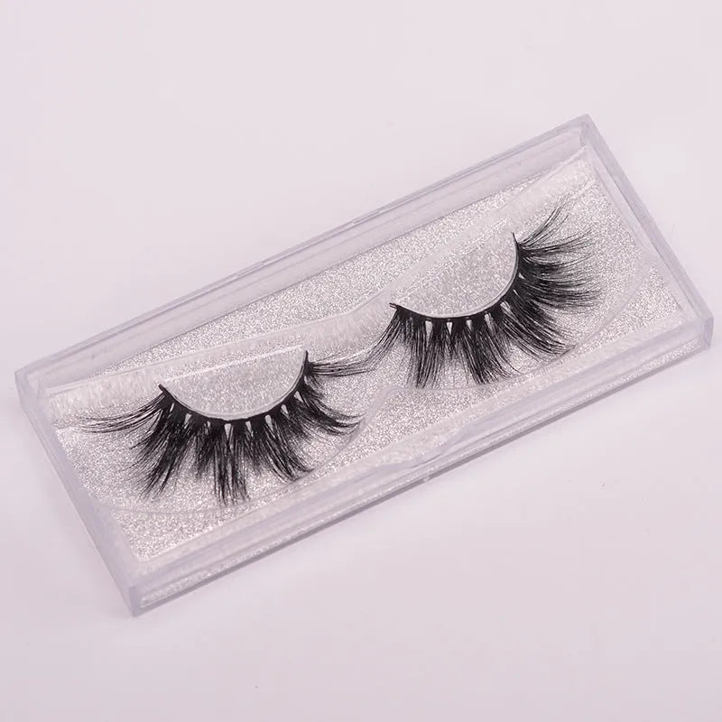 Handmade 5D mink false eyelashes set with brush and storage cap on a white background.