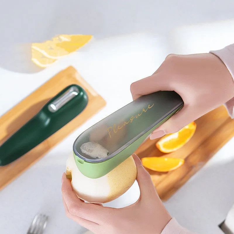 Dark green kitchen peeler with stainless steel blade inside its clear plastic storage tube