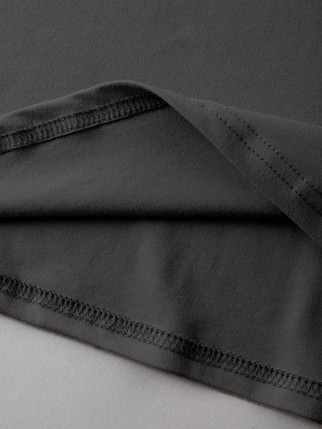 Loose fit cotton t-shirt in black with round neck and short sleeves on a hanger