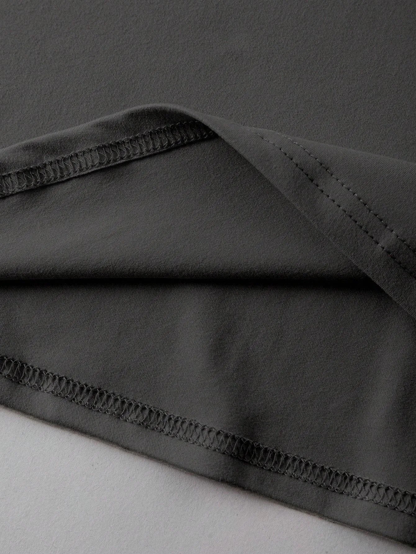 Loose fit cotton t-shirt in black with round neck and short sleeves on a hanger