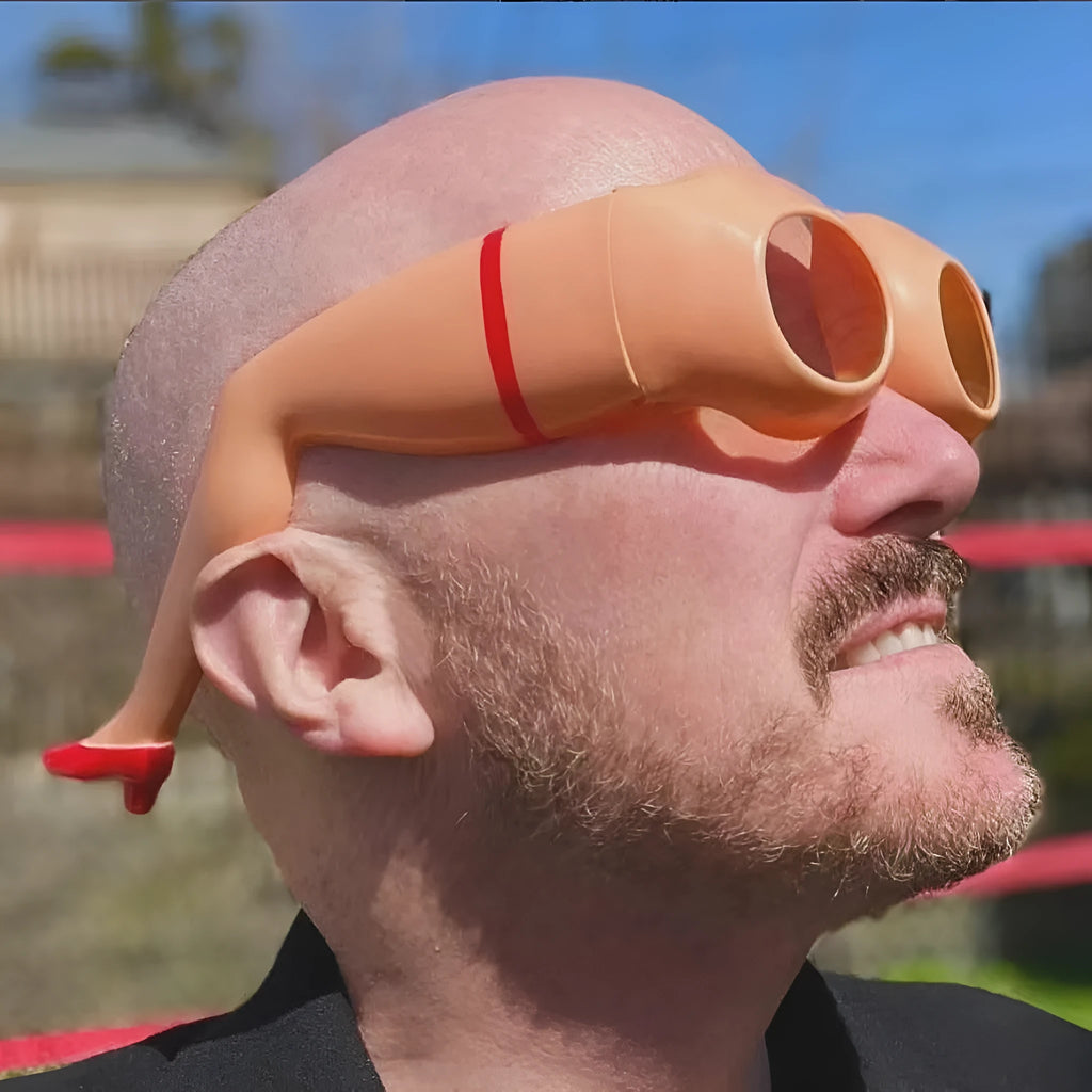 Orange novelty sunglasses with a leg and hip design on a white background.